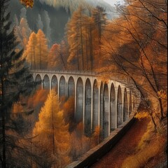  Old viaduct bridge enveloped in fog with autumn colors in the surrounding forest.