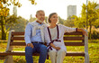 © Studio Romantic - Happy senior couple with smiles, adorned in casual wear, takes a moment to sit on a bench during leisurely stroll. This heartwarming scene encapsulates the joy of their vacation and holiday.