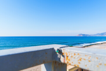 Wall Mural - Clear Blue Sea and Sandy Beach from a Pedestrian Bridge Crosswalk Under the Clear Sky in a Sunny Bright Day