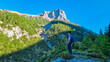 Hiker man with panoramic view of majestic mountain peak Foelzstein in untamed Hochschwab mountain region, Styria, Austria. Scenic hiking trail on in remote Austrian Alps. Wanderlust in alpine summer