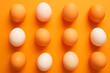 Assorted Brown and White Eggs on Vibrant Orange Background
