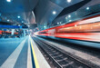 © den-belitsky - High speed train in motion on the railway station at night. Fast moving red modern intercity passenger train, railway platform with illumination. Modern train station in Vienna, Austria. Railroad