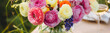 Bouquet of fresh bright colourful ranunculi flowers in a glass vase. Floral wedding decor. Banner