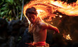 Hawaiian fire dancer performs at a luau at night