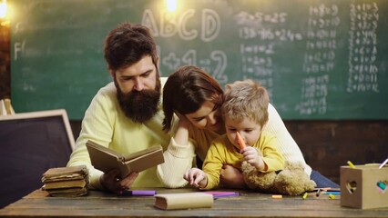 Fototapete - Cute clever boy study. Kids learning and education concept. Happy family. Mother father and son together schooling. Boy from elementary school.
