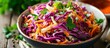 © AkuAku - Fresh and colorful red cabbage and carrot salad in a white bowl on a wooden table