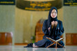 © maya1313 - Ramadan, The image of an Asian Muslim woman in the Islamic religion in hijab in black color. reading the Quran and having a happy smiling face Staying in a beautiful mosque out of respect for God.