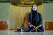 © maya1313 - Ramadan, The image of an Asian Muslim woman in the Islamic religion in hijab in black color. reading the Quran and having a happy smiling face Staying in a beautiful mosque out of respect for God.