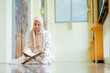 © maya1313 - Ramadan, quran, The image of an Asian Muslim woman in the Islamic religion in hijab in cream color. reading the Quran and having a happy Staying in a beautiful mosque, Arabic word Holy Al Quran.