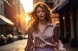 Fashion-forward woman in a mauve blouse and striped trousers, walking confidently down a busy city street bathed in the warm glow of the evening sun