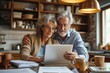 Affectionate elderly couple browsing on a tablet and sharing a moment together in a homey kitchen