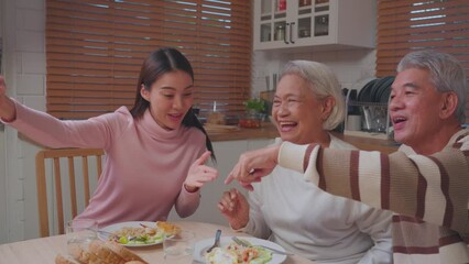 Wall Mural - Asian family doing video call while having lunch in house together. 