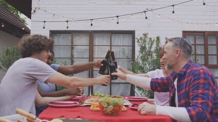 Wall Mural - Multi-ethnic family having fun, enjoy party outdoors in the garden.