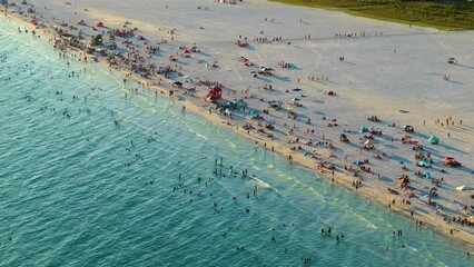 Wall Mural - Famous Siesta Key beach with soft white sand in Sarasota, USA. Many people enjoying vacation time bathing in warm gulf water and tanning under hot Florida sun at sunset