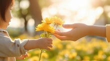 Mother And Daughter Hand Holding Yellow Flowers In The Park, Family And Happy Childhood Concept.