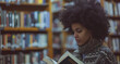a woman with afro highlights looks books