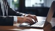 © Naknakhone - Close up of a business man working on a laptop, typing with his hands for work in office environment home office. copy space for text.