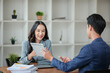 © Treerat - Two business workers smiling happy working sitting on desk at the office.