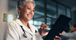 © peopleimages.com - Doctor, mature woman and happy with tablet in night, typing or smile for results, meme or notification in hospital. Senior nurse, digital touchscreen or funny video with click, scroll or social media