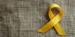 Yellow ribbon on textile background with copy space for endometriosis awareness month or sign for microencephaly and suicide prevention