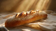Freshly baked baguette on a cloth in sunlight.