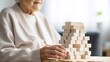 Faceless elderly woman with dementia playing with wooden blocks in geriatric clinic or nursing home close-up