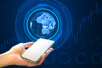 Canvas Print - Close up of female hand holding white mock up smartphone with holographic screen with digital globe interface and business chart on blurry blue background. HUD, international stock and future concept.