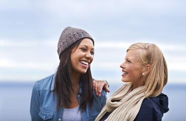 Canvas Print - Friends, laughing and women by ocean for adventure on holiday, vacation and weekend outdoors. Nature, travel and people talking by seaside for relaxing, happiness and bonding together in countryside