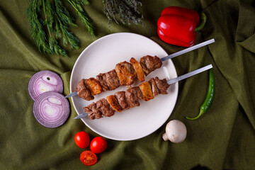 two sticks of lumpy beef kebab on a plate