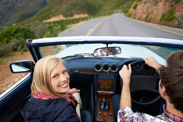 Poster - Couple, driving and convertible steering wheel on mountain from behind for vacation happy, adventure or holiday. Man, woman and portrait on transportation in California for travel, relax or nature