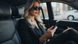 A beautiful young successful businesswoman uses a smartphone in the car during a trip, communicates with business partners, and types a message to friends and family.