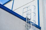 Fototapeta  - vertical aluminum escape ladder  entrance to the roof