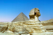 full profile of the Great Sphinx with the pyramid in the background in Giza.