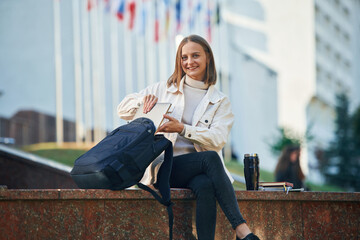 Wall Mural - Cheerful, smiling. Young female student in casual clothes is outdoors