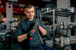 © Guys Who Shoot - the chef stands in the kitchen in black jacket and sharpens his knives before cooking something tasty