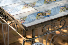 Porcelain Antique Table With Iron Work Standing In A Courtyard