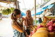 © Connect Images - Two young women one wearing a Hijab buying dragon fruit in a rural town in Thailand