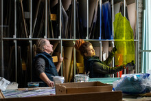 Male And Female Stained Glass Workers Inspecting Coloured Glass