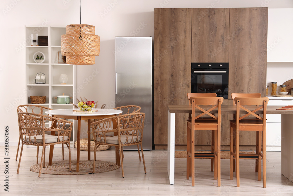 Interior of modern kitchen with tables and built-in oven