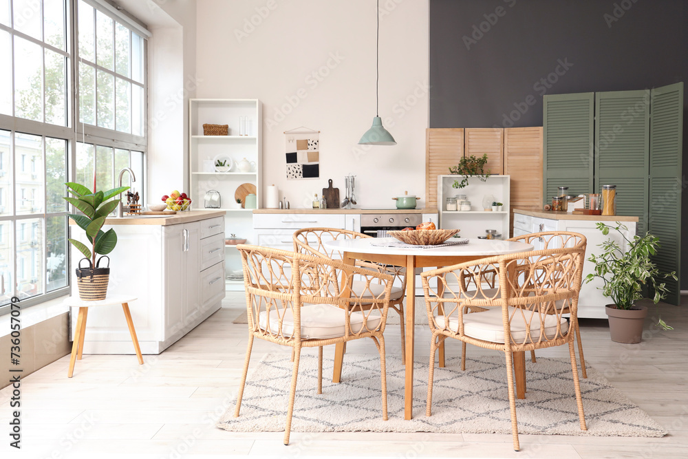 Interior of kitchen with dining table, counters and houseplants