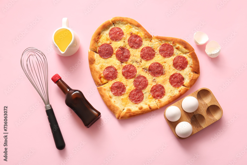 Tasty heart shaped pizza and ingredients on pink background