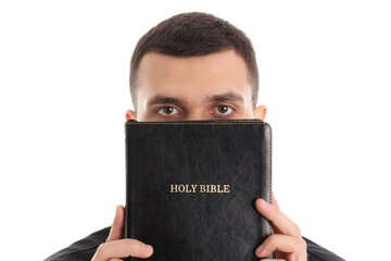 Wall Mural - Young priest with Holy Bible on white background, closeup