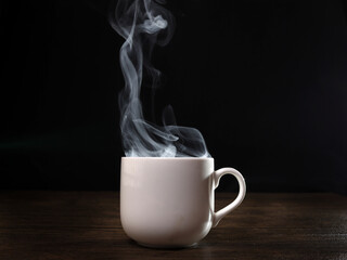 Wall Mural - Smoke vape fog flowing out of white ceramic coffee cup on dark black background