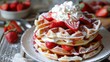 A stack of fluffy waffles topped with fresh strawberries, whipped cream