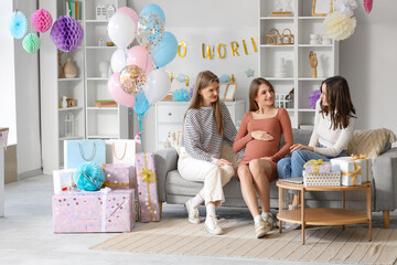 Poster - Young pregnant woman with her friends sitting on sofa at baby shower party