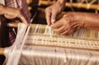 hands adjusting tension of warp threads on a loom