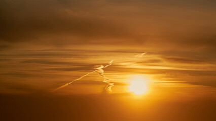 Wall Mural - As the sun began to dip below the horizon, the clouds turned shades of yellow and orange.