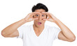 © pathdoc - Closeup portrait of young, curious funny man, student, employee looking through his fingers like binoculars, surprised, shocked by what he found in future, isolated on white background