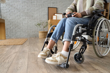 Poster - Young woman in wheelchair playing video game at home