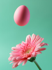 Wall Mural - Easter egg flying and levitating over a pink flower on light cyan background. Creative Easter holiday concept.